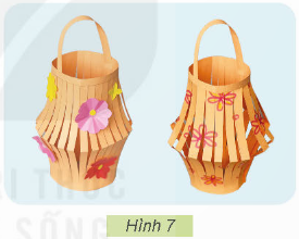 1. TÌM HIỂU SẢN PHẨM MẪUKhám phá: Em hãy quan sát mẫu đèn lồng trong Hình 1 và cho biết các bộ phận chính của chiếc đèn lồng.Yêu cầu sản phẩm: Lồng đèn tròn đều, cân đối, quai xách ở vị trí phù hợp, màu sắc hài hòa, trang trí đẹp, đèn chắc chắn.Giải chi tiết:Các bộ phận chính của chiếc đèn lồng là:Quai xách.Lồng đèn 2. VẬT LIỆU VÀ DỤNG CỤKhám phá: Em hãy lựa chọn các vật liệu với số lượng phù hợp và dụng cụ cần thiết có trong Hình 2 để làm đèn lồng.Giải chi tiết:Các vật liệu phù hợp để làm đèn lồng là:1 tờ giấy bìa màu.Nhiều giấy màu thủ công.Dụng cụ cần thiết để làm đèn lồng là:1 bút chì.1 thước kẻ.1 kéo.1 cuộn băng dính hai mặt.1 bút màu. 3. THỰC HÀNHThực hành: Em hãy làm sản phẩm theo các bước dưới đây.Bước 1. Làm lồng đèn- Chuẩn bị một tờ giấy bìa màu hình chữ nhật có chiều dài 22cm, chiều rộng 15cm. Gấp đôi tờ giấy bìa màu theo chiều dọc và kẻ các đường song song cách nhau 1cm như Hình 3.- Cắt tờ giấy bìa màu theo các đường kẻ song song (Hình 4a) và mở ra, sẽ được sản phẩm như Hình 4b.Lưu ý: Sử dụng kéo an toàn.- Dùng băng dính hai mặt để dán hai mép tờ giấy bìa màu tạo thành lồng đèn như Hình 5.Bước 2. Làm quai xách- Cắt một miếng giấy bìa màu hình chữ nhật có chiều dài 16cm, chiều rộng 2cm làm quai xách của đèn.- Gắn quai xách vào phần trên của lồng đèn cho cân đối (Hình 6).Bước 3. Hoàn thiện sản phẩm- Dùng bút chì màu, giấy màu trang trí đèn lồng theo ý thích (Hình 7).- Kiểm tra độ chắc chắn của đèn lồng và điều chỉnh (nếu cần).Lưu ý:- Thu dọn và vệ sinh chỗ học tập sau khi làm xong sản phẩm.- Sử dụng tiết kiệm vật liêu.Đáp án:Học sinh thực hành làm đèn lồng theo các bước. 4. GIỚI THIỆU SẢN PHẨM
